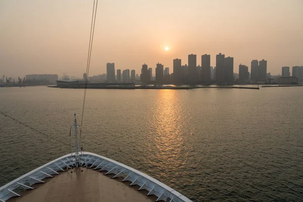 Sun rising behind the tall city skyline of Qingdao in China — Stock Photo, Image