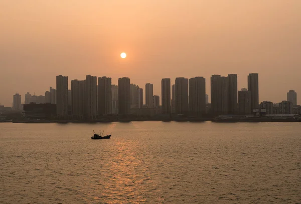 Solen stiger bakom höga stadssilhuetten i Qingdao i Kina — Stockfoto