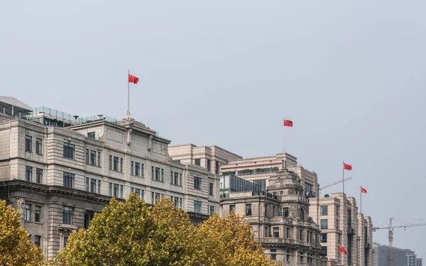 Edifícios históricos com bandeiras chinesas no The Bund em Xangai — Fotografia de Stock