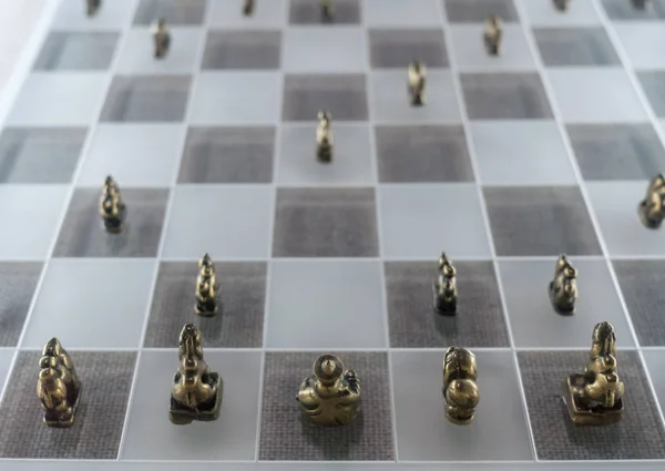 Cast metal chess men on glass board — Stock Photo, Image