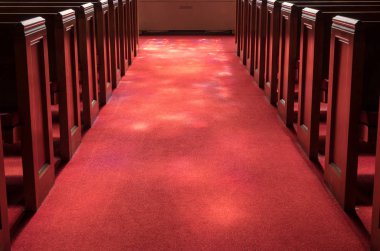 Light rays from stained glass window light up church aisle clipart