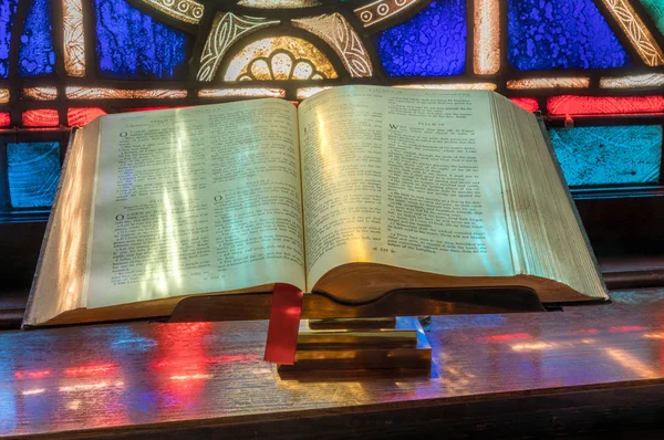 La luz de la vidriera cae sobre la biblia abierta en la iglesia americana —  Fotos de Stock