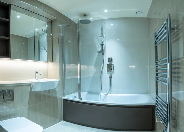 Moderno baño en apartamento con bañera de ducha y superficies de baldosas —  Fotos de Stock