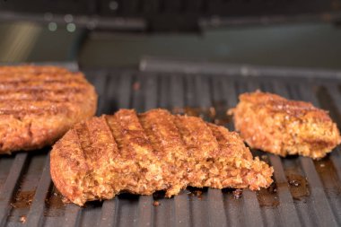 Izgara ızgara üzerinde bitki bazlı burger köftesi yakın