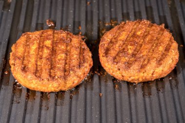 Izgara ızgara üzerinde bitki bazlı burger köftesi yakın