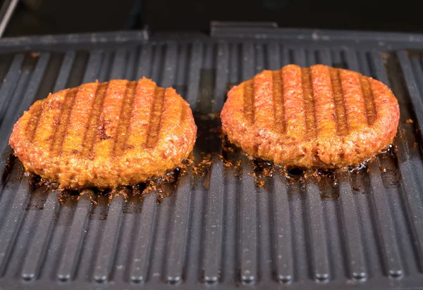 Close up of plant based burger patties on griddle being grilled — Stock Photo, Image