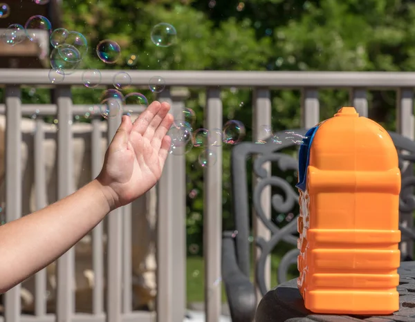 Childs fabricante de burbujas de jabón mecánico o ventilador con las niñas de la mano en frente — Foto de Stock