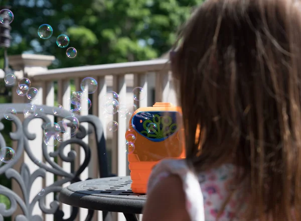 Childs mechanical soap bubble maker or blower with girl in front — Stock Photo, Image