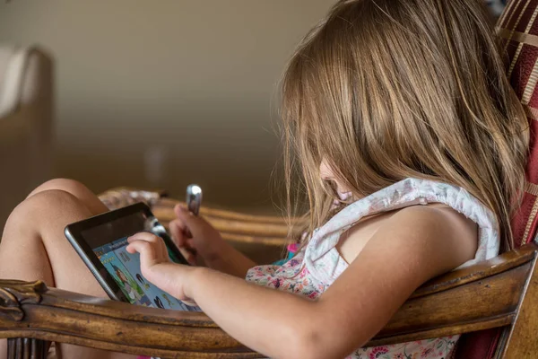 Young preschooler playing with a modern electronic tablet — Stock Photo, Image