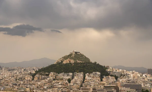 La colline de Lycabettus s'élève au-dessus d'Athènes le jour de tempête — Photo