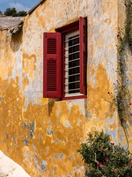 Rode luiken op venster in de oude wijk van Anafiotika in Athene Griekenland — Stockfoto