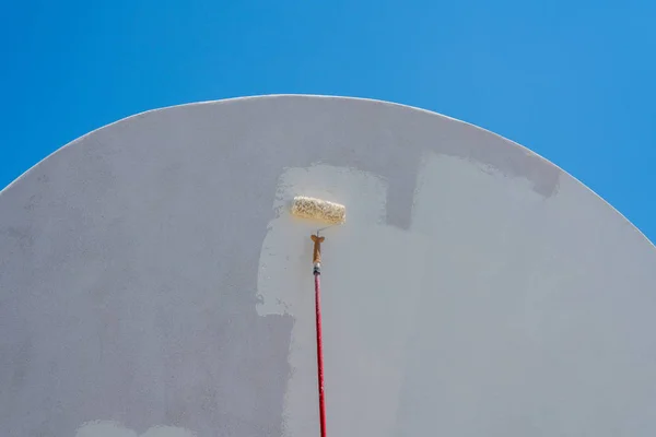 Worker repainting traditional cave house on Santorini — Stock Photo, Image