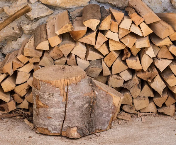 Pile de bois de chauffage contre mur de pierre de ferme — Photo