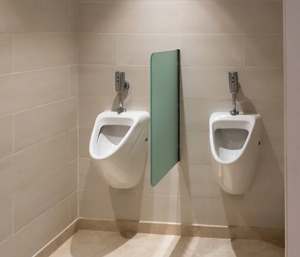 Dos urinarios de descarga automática en el baño para hombres —  Fotos de Stock