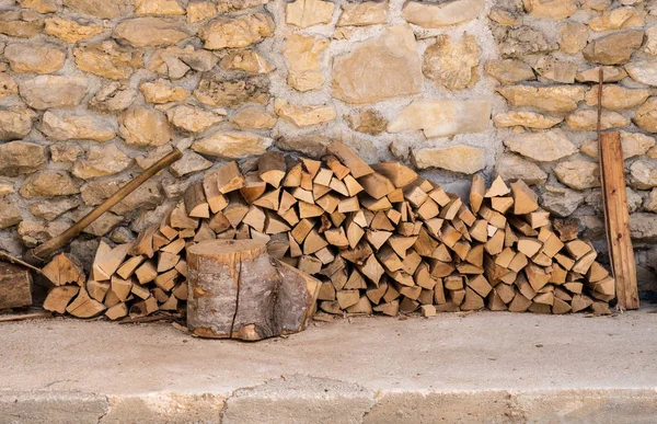 Стопка дров против каменной стены фермерского дома — стоковое фото