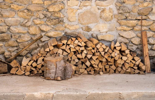 Pila de leña contra la pared de piedra de la granja — Foto de Stock