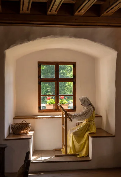 Kvinna i uppvisning av livet i Predjama slott inbyggt i en grotta i Slovenien — Stockfoto