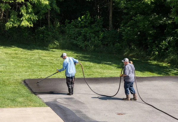 Trabajadores rociando blacktop o sellador de asfalto en la carretera — Foto de Stock