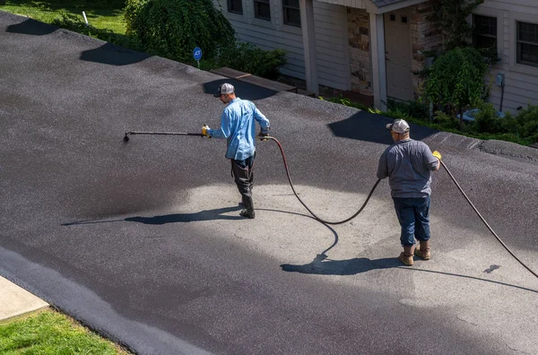 Trabajadores rociando blacktop o sellador de asfalto en la carretera — Foto de Stock