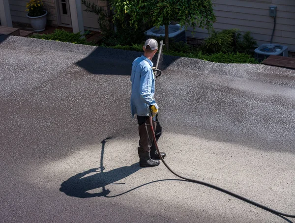 Trabalhadores pulverizando blacktop ou asfalto selante na estrada — Fotografia de Stock