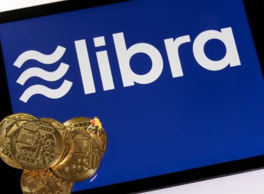 Terazi siber para birimi için tablet bilgisayarın üstünde altın sikkeler
