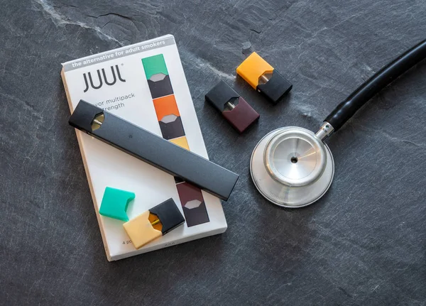 Boîte contenant distributeur de nicotine JUUL et dosettes avec stéthoscope — Photo