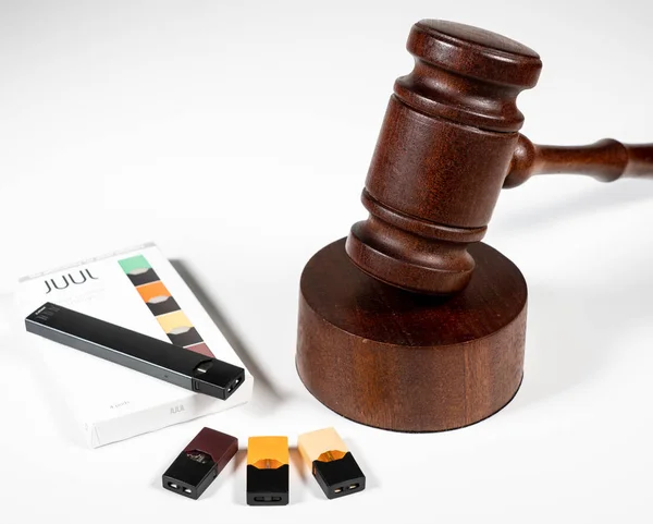 Box holding JUUL nicotine dispenser and pods with court judge gavel — Stock Photo, Image