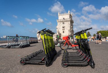 Mulitple electric scooters in Lisbon by the Belem Tower clipart