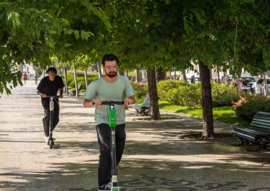 Liberty Avenue boyunca kireç elektrikli scooter sürme İnsanlar
