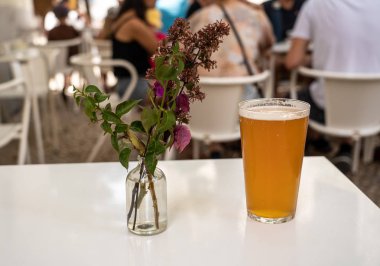 Lizbon bar veya kafede çiçeklerle beyaz masada serin Ipa Pint