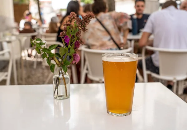 Pinta de IPA fresco sobre mesa blanca con flores en Lisboa bar o cafetería —  Fotos de Stock