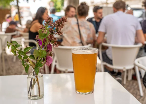 Pinta de IPA fresco sobre mesa blanca con flores en Lisboa bar o cafetería —  Fotos de Stock