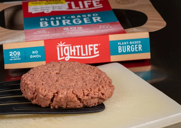 Burger à base de plantes Lightlife devant l'emballage de deux galettes — Photo