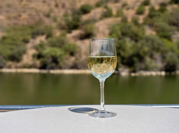 Verre de vin blanc sur un bateau de croisière sur le fleuve Douro au Portugal — Photo