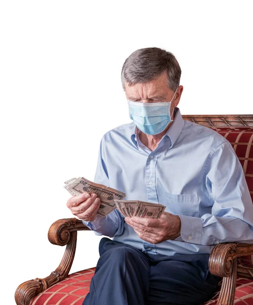 Senior man räknar bort amerikanska dollarsedlar med ansiktsmask och ser orolig ut — Stockfoto