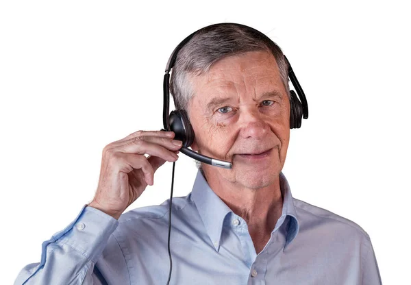 Старший чоловік використовує гарнітуру для спілкування з командою або клієнтами — стокове фото