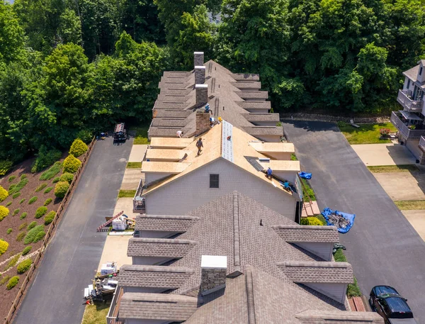 Drohnenblick eines Dachdeckerunternehmers, der Schindeln von einem Dach entfernt, das für die Dachsanierung bereit ist — Stockfoto