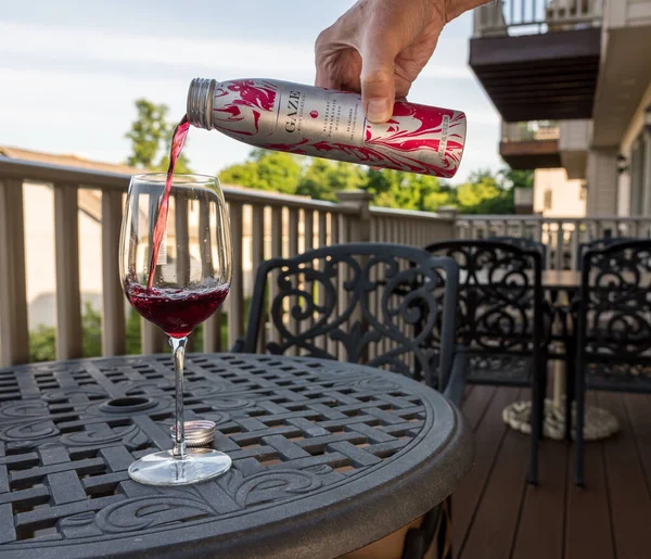 Canette de cocktail de vin Gaze étant versé dans un verre de vin sur le patio extérieur ou le pont — Photo