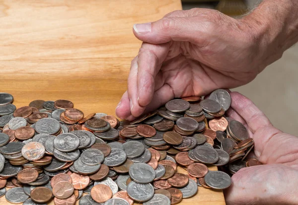 Hands scooping up loose USA change with mixed coins on wooden table — Stock Photo, Image