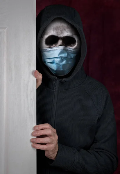 Halloween theme of stalker with skull and face mask against coronavirus entering a home — Stock Photo, Image
