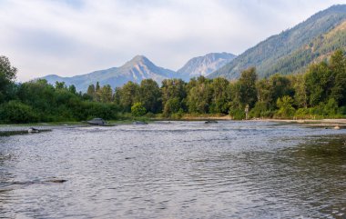 Wenatchee Nehri, Alman şehri Leavenworth WA 'daki dağları ve bulutları yansıtıyor.