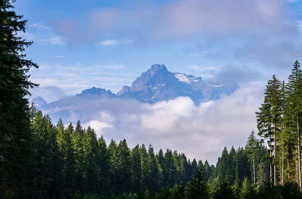 Whitehorse Mountain seen through rolling clouds and mist from Route 530 in North Cascades Washington State