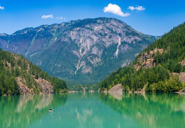 Kuzey Cascades Ulusal Parkı 'ndaki Diablo Gölü' nde tek raket yüzüyor. Buzul unu göle turkuaz rengini veriyor.