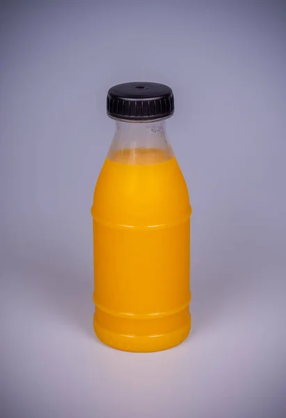 Sumo de laranja numa garrafa de plástico — Fotografia de Stock