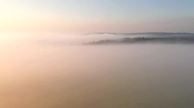 Şafaktan önce ovayı kaplayan kalın bir sis üzerine bir dron atışı. UHD 4k video ile çekildi.