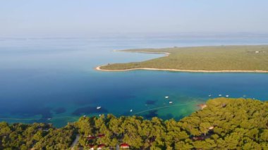 Güneşli bir günde Cres adasının mavi gölünün muhteşem manzarası. UHD 4k insansız hava aracı videosunda çekildi.