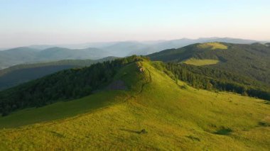 Bir dron dağlık dağlardaki yeşil çayırlar üzerinde uçuyor. UHD 4k video ile çekildi.
