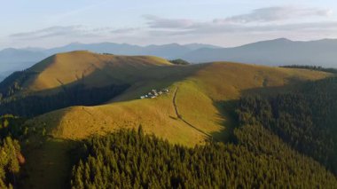 Yeşil tepelerdeki bir kuş bakışı dağ yerleşiminden. UHD 4k video ile çekildi.