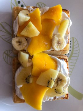 Kolay Belçika Waffle 'ları dıştan çıtır çıtır, içi yumuşaktır üstüne krema, muz ve mango koymak için mükemmeldir.