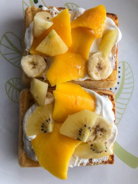 Kolay Belçika Waffle 'ları dıştan çıtır çıtır, içi yumuşaktır üstüne krema, muz ve mango koymak için mükemmeldir..